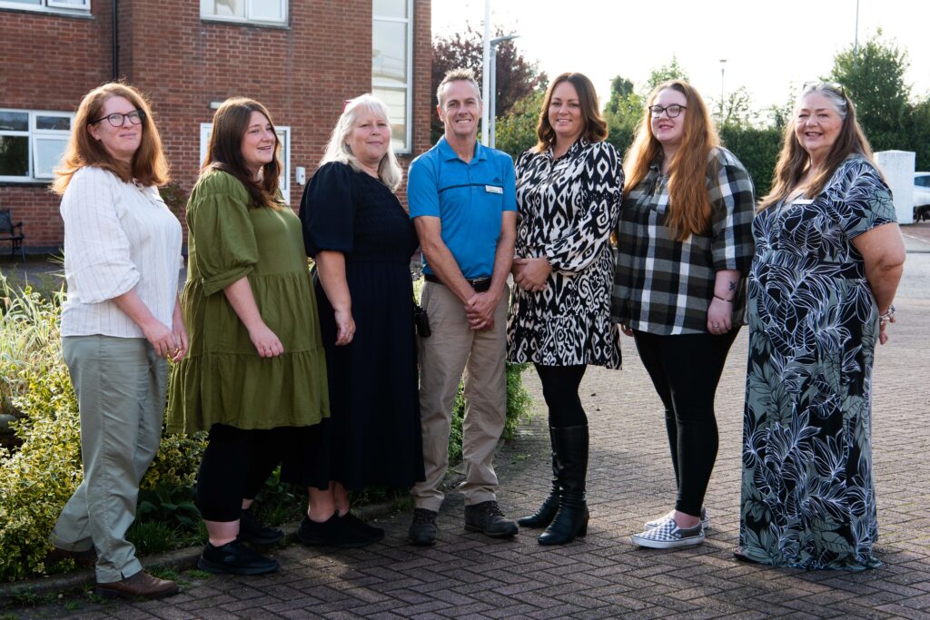 Devonshire Court Home Management Team gathered in front of the care home, showcasing unity and community spirit.