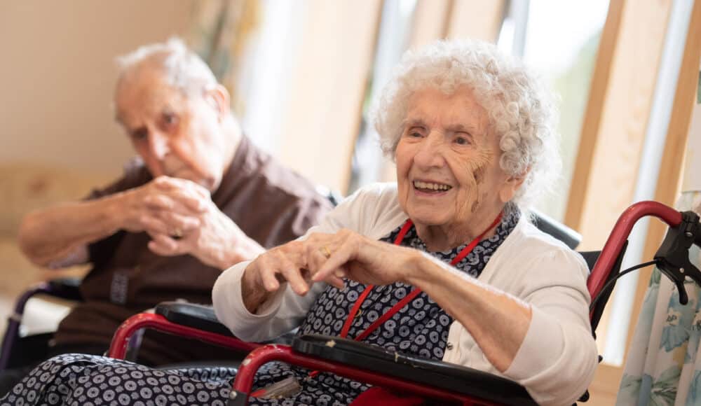 Two residents stretch out their arms during a gentle exercise class at James Terry Court care home.