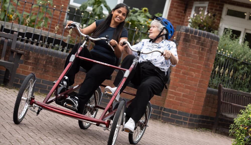 Resident and staff member enjoying a bik