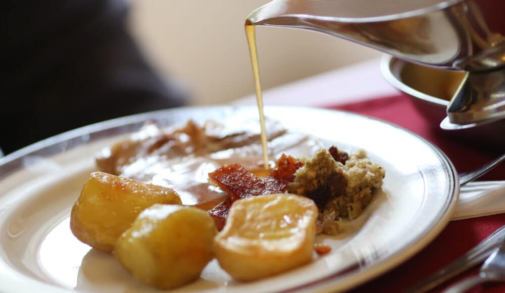 Sauce being poured over hot food.