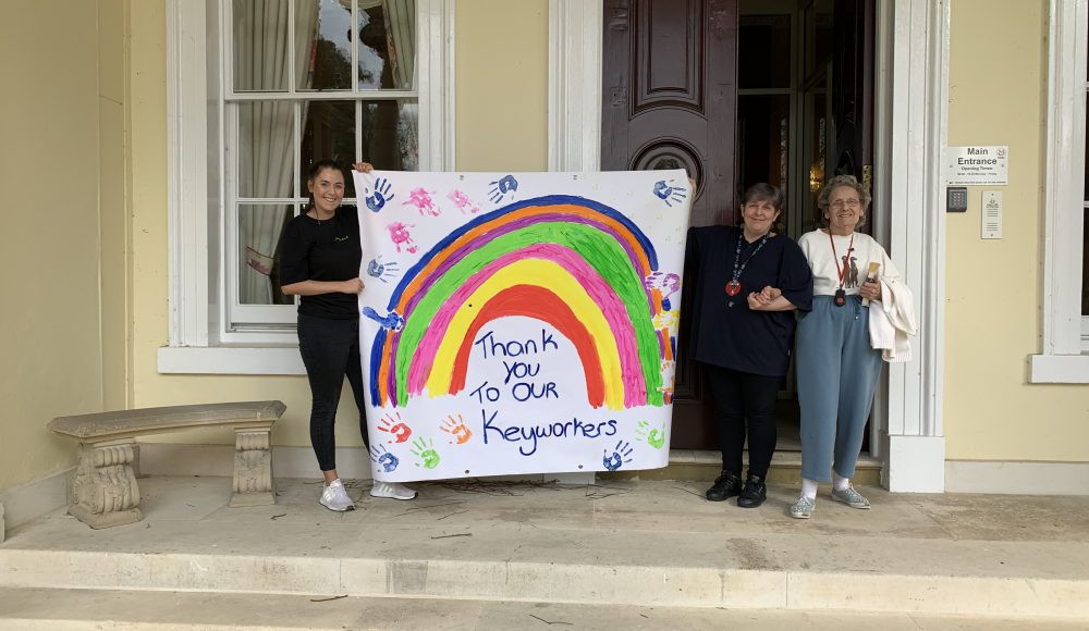 Residents hold up rainbow art to thank key workers at Prince Edward Duke of Kent Court