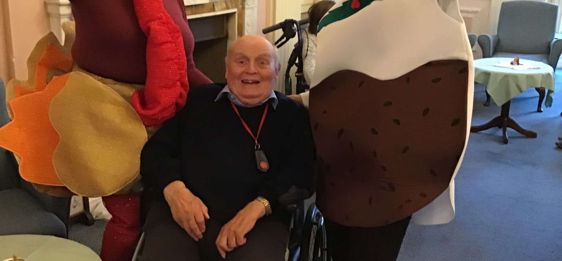Staff in Christmas dress up with resident at Zetland Court