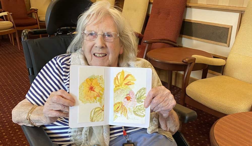 Resident Christine Goody, aged 85 at RMBI Care Co.Home Queen Elizabeth Court with her flowers painting