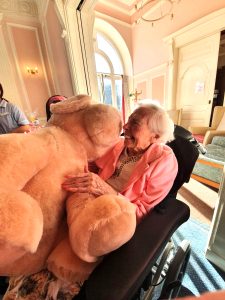 Resident Nina Ansell hugs the giant cuddly bear she won at the Home’s Breast Cancer Awareness raffle.