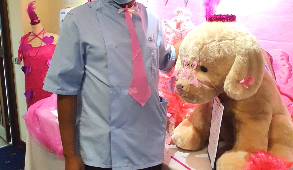 Staff member Joseph Masiwa poses next to the giant cuddly bear