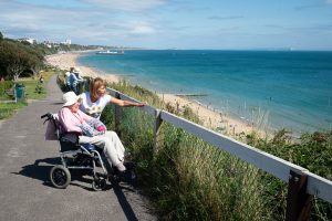 Activities Coordinator Karen Casey enjoys a sunny afternoon with one of Zetland Court’s residents at the beach promenade in Bournemouth, just a short walk away from the care home.