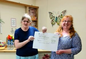 Resident Annette Gibbs and Deputy Home Manager for the Dementia House Susan Wiffen at Zetland Court, in Bournemouth, holds a £4000 cheque from Gibb & Whitbread. The Home will use the donation to upgrade their courtyard garden for people living with dementia to enjoy. 
