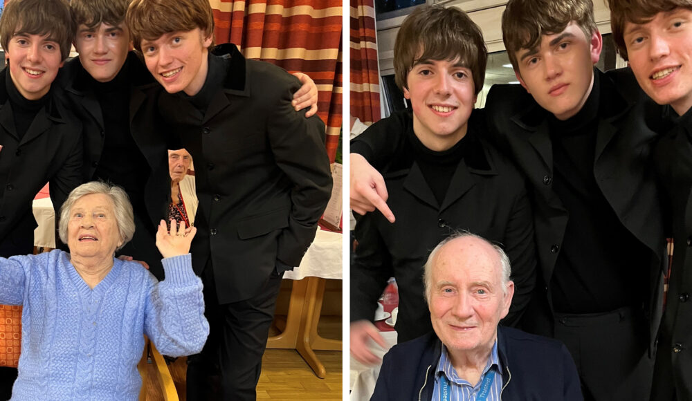 On the left, resident Stevie in a blue jumper at RMBI Care Co. Home Prince George Duke of Kent Court, in Chislehurst, in awe of the three young boys from Liverpool Lads, a Beatles tribute band. On the left, resident Paul in a stripy shirt and navy jacket poses with the three young boys Alex, Michael and Alex from Liverpool Lads at RMBI Care Co. Home Prince George Duke of Kent Court, in Chislehurst.