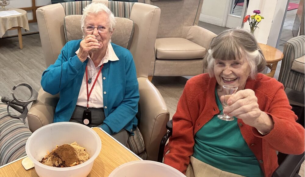 Residents Rita and Pam enjoy a cheeky glass of brandy while enjoying a Christmas pudding-making session.