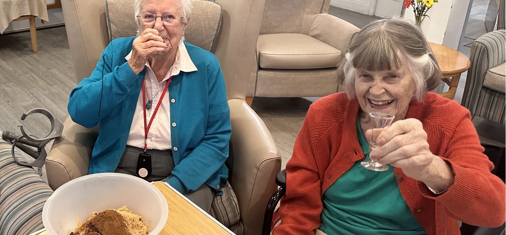 Residents Rita and Pam enjoy a cheeky glass of brandy while enjoying a Christmas pudding-making session.