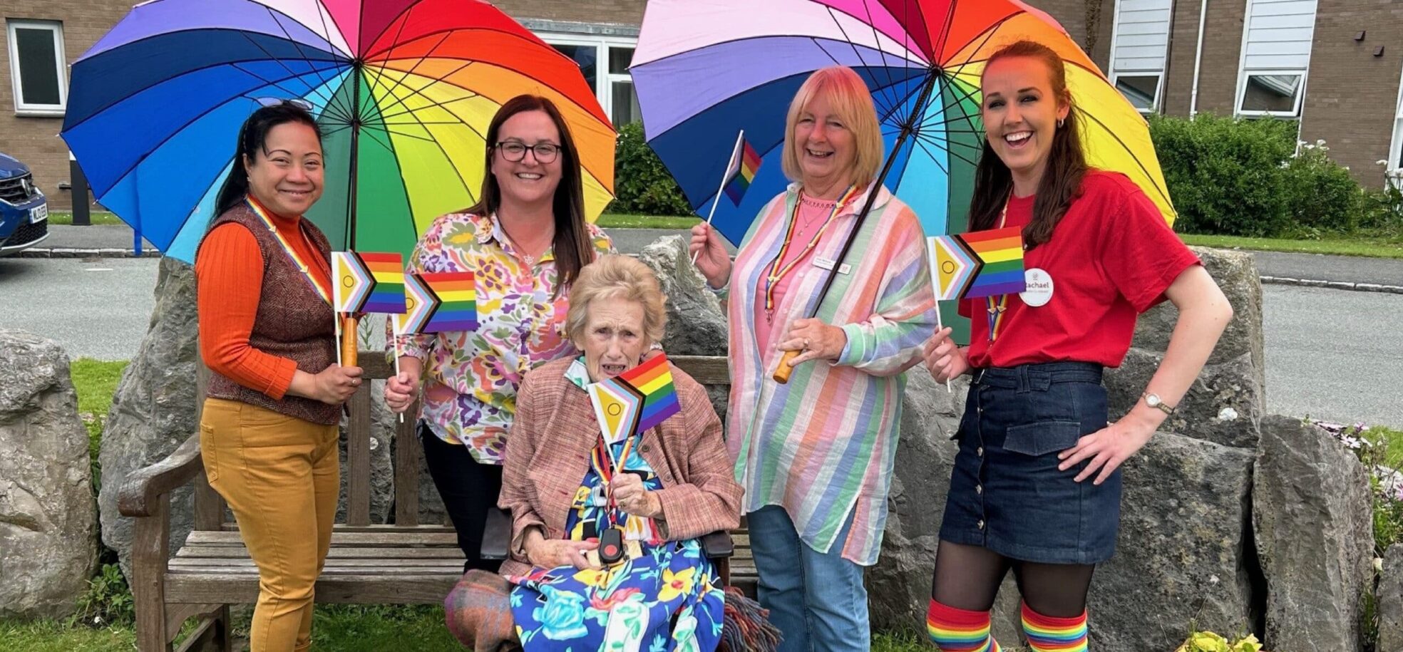 Resident Maureen celebrating Pride Month with the Home Management Team at RMBI Care Co. Home Queen Elizabeth Court, in Llandudno