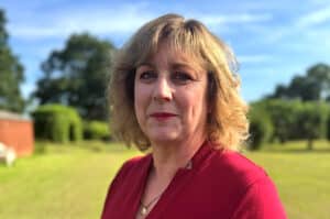 Hazel Salter wearing a red dress and standing outdoors.