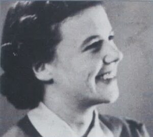An old black and white picture of a woman smiling.
