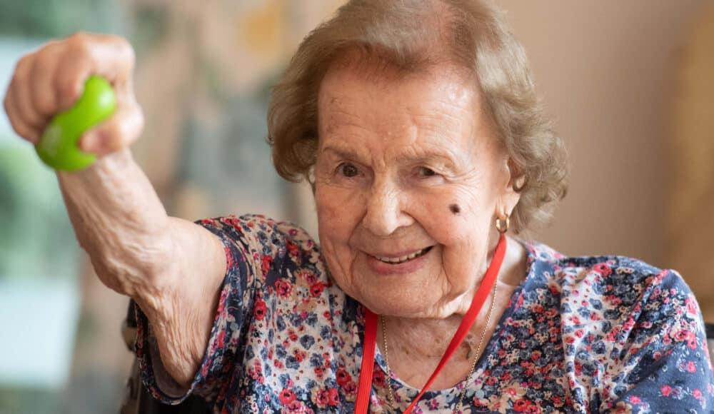 Pat Hamilton smiles while lifting a green ball.