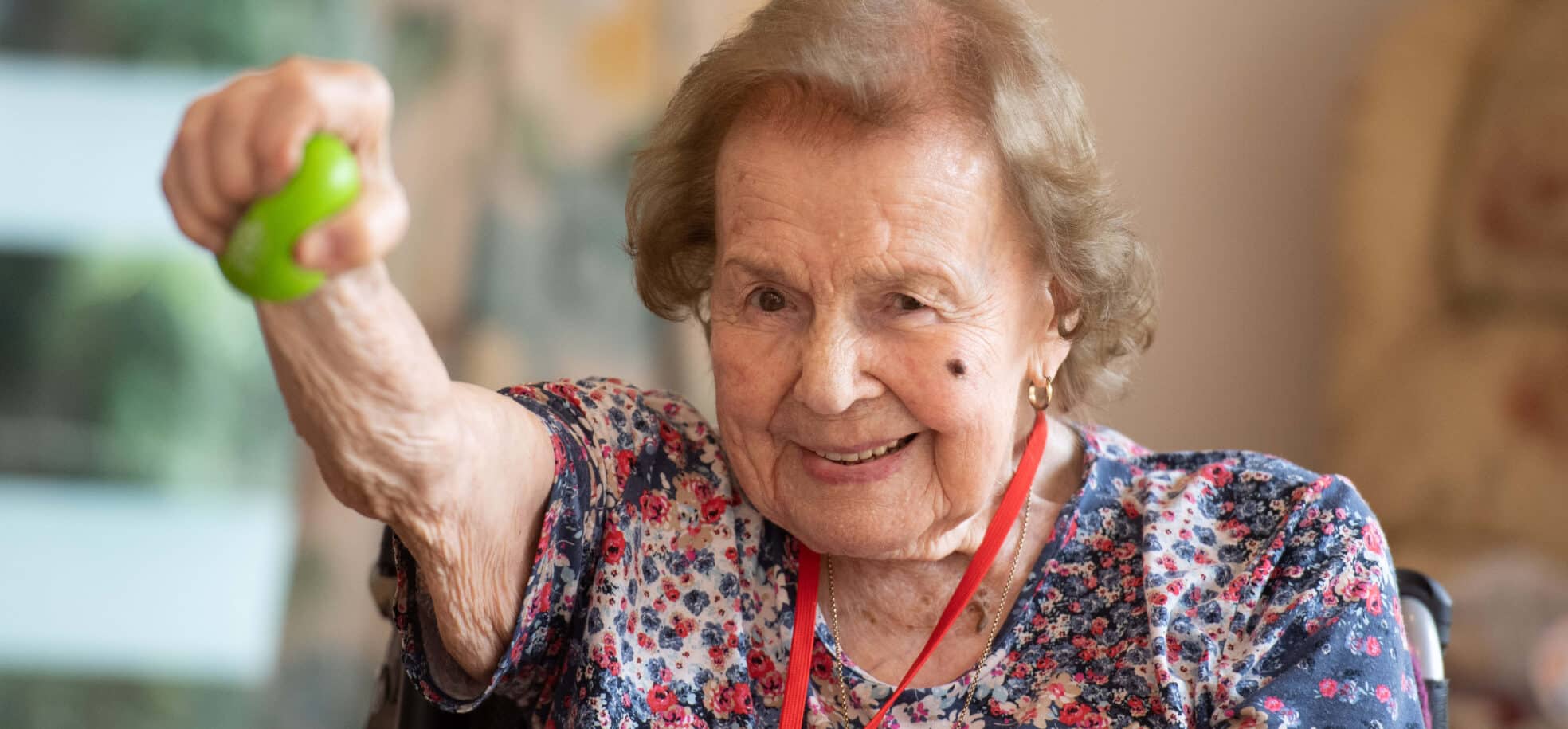 Pat Hamilton smiles while lifting a green ball.