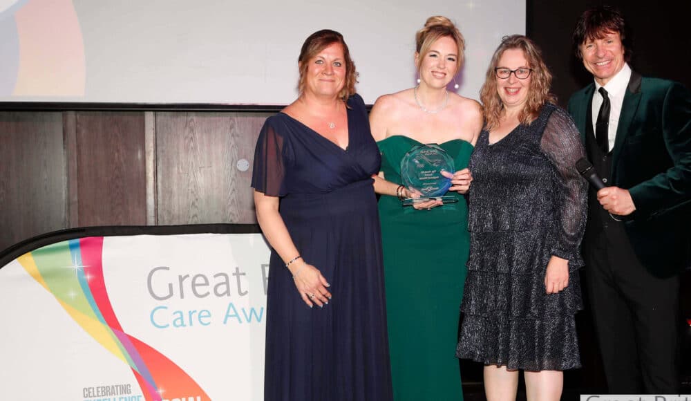Three staff members with the host at the Great British Care Awards.
