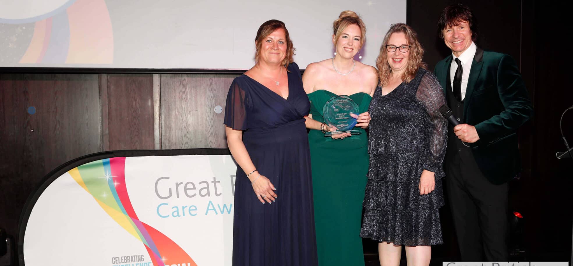 Three staff members with the host at the Great British Care Awards.