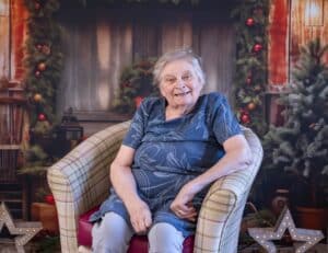 A female care home resident sitting in a comfortable armchair.
