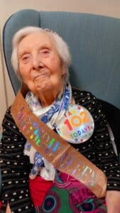 A female care home resident smiling during her birthday.