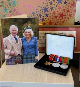 The resident's medals and a birthday card from the King and Queen Consort.