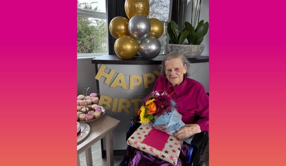 Kay poses proudly with flowers, a present and sweet treats at her birthday party