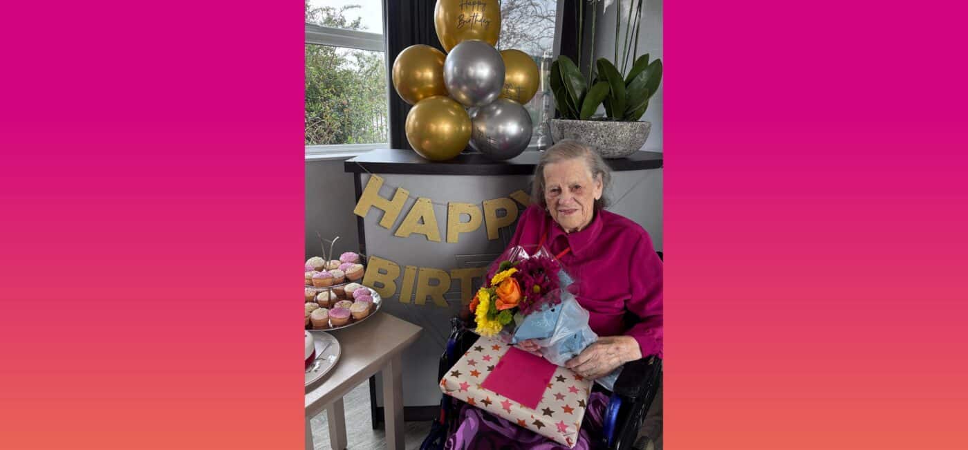 Kay poses proudly with flowers, a present and sweet treats at her birthday party