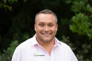 Home Manager Gavin Kingham smiling in the Home's garden.